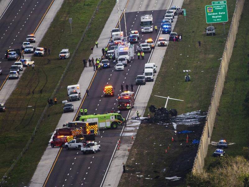 Emergency officials at the scene of a small plane crash on a Florida highway, in which two died. (AP PHOTO)